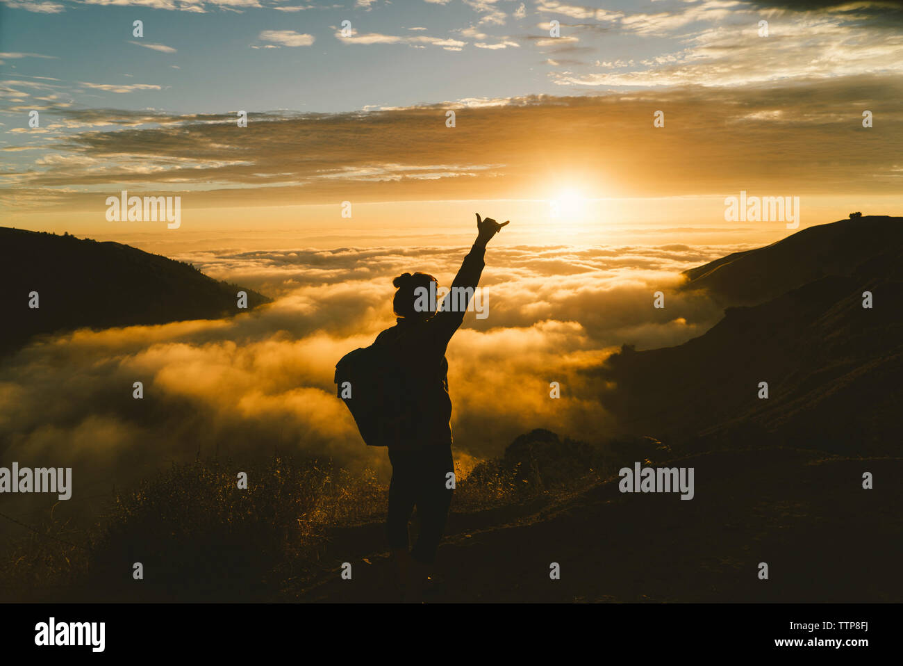 Silhouette weibliche Wanderer Gestik beim Stehen auf die Berge bei Sonnenuntergang Stockfoto