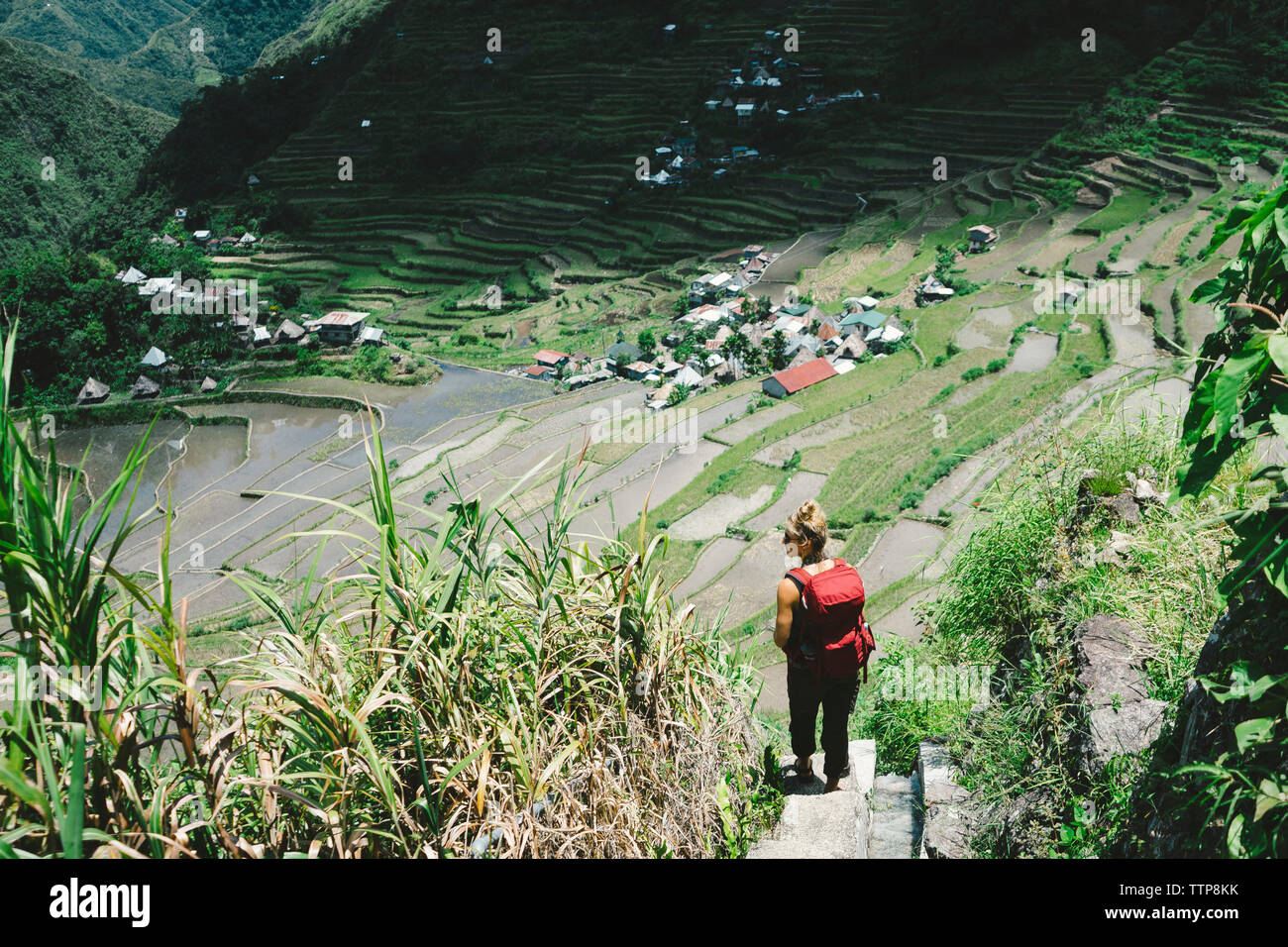 Ansicht der Rückseite des weiblichen Wanderer mit Rucksack stehen auf der Terrasse im Dorf Stockfoto