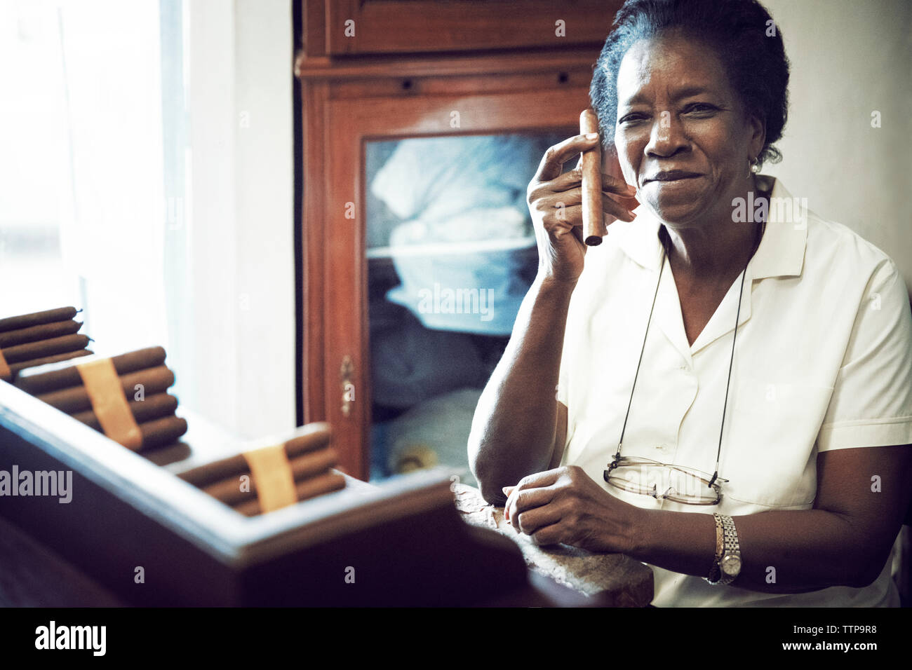 Portrait von Frau mit Zigarre beim Sitzen in der Factory Stockfoto