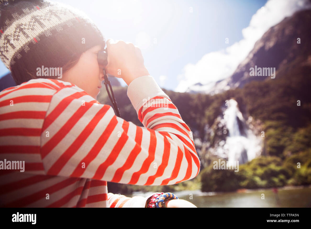 Seitenansicht des Jungen durch Fernglas an einem sonnigen Tag auf der Suche Stockfoto