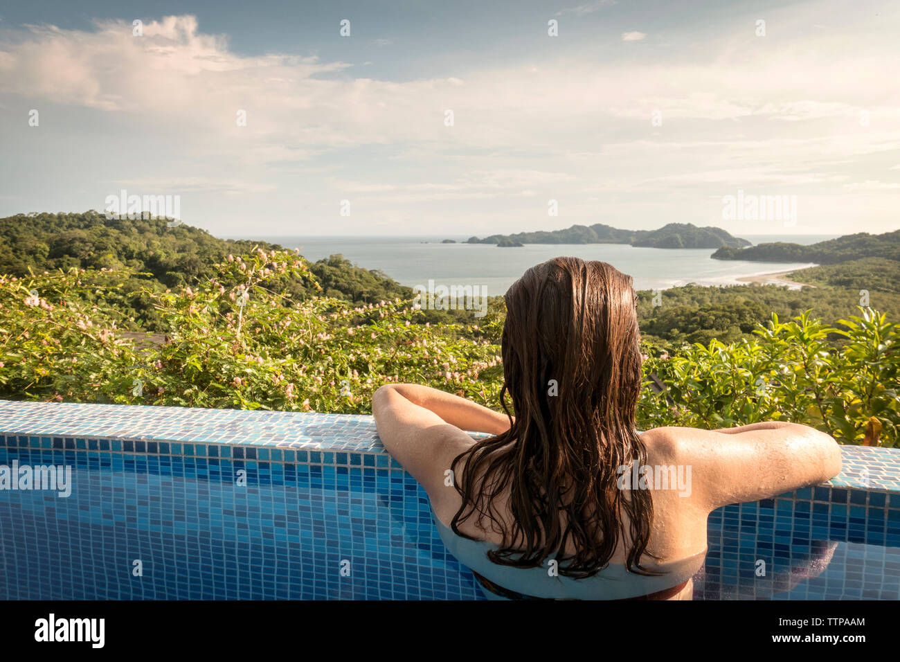 Rückansicht der Frau in der Swimmingpool und Blick auf Costa Rica Stockfoto
