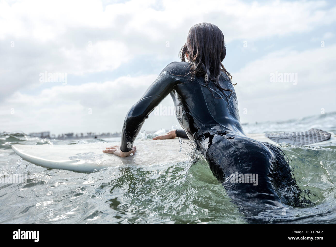 Ansicht der Rückseite des weiblichen Surfer liegen auf Surfbrett im Meer Stockfoto