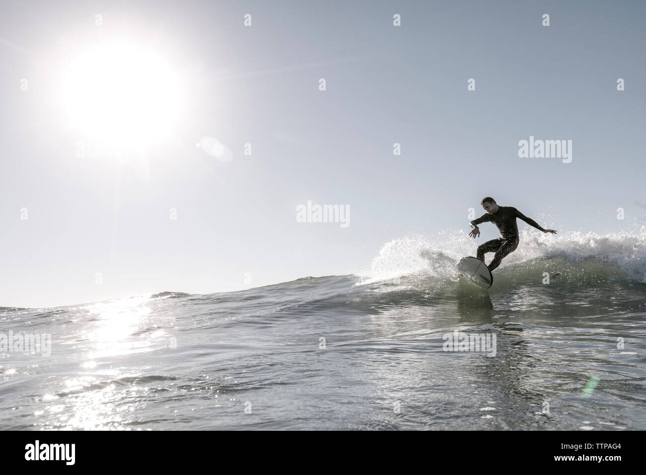 Mitte der erwachsene Mann surfen auf sehr große Welle im Meer gegen den klaren Himmel während der sonnigen Tag Stockfoto