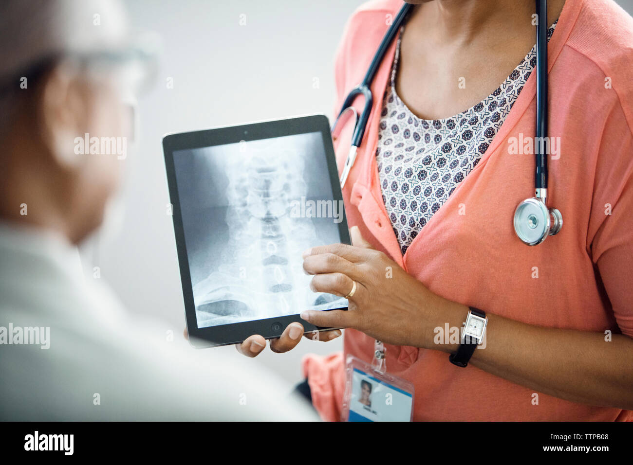 Mittelteil der weiblichen Doktor x - ray auf Tablet-PC zu Patient Stockfoto