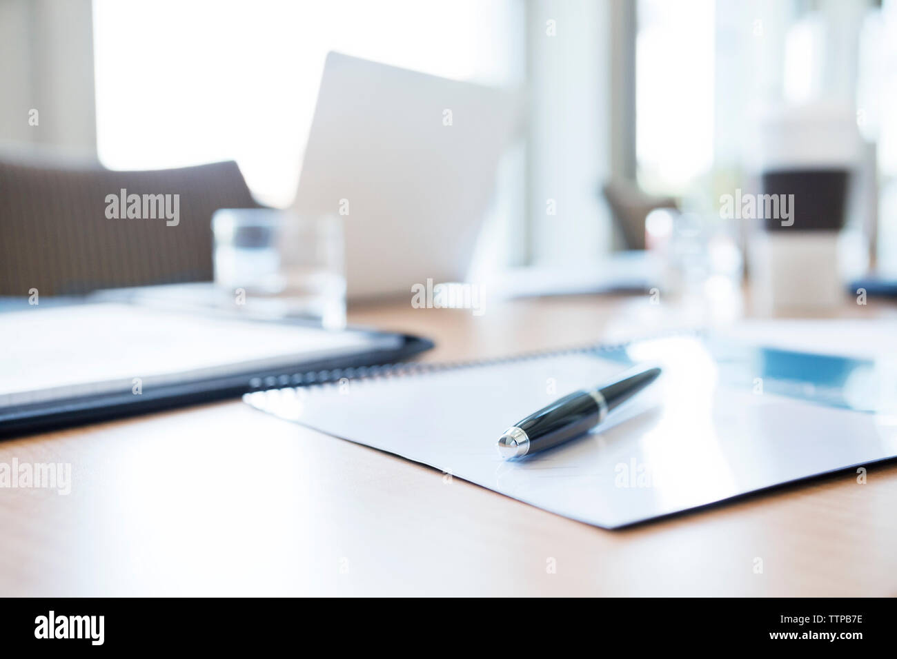 Notizblock und Stift von Tablet-PC auf dem Tisch im Konferenzraum Stockfoto