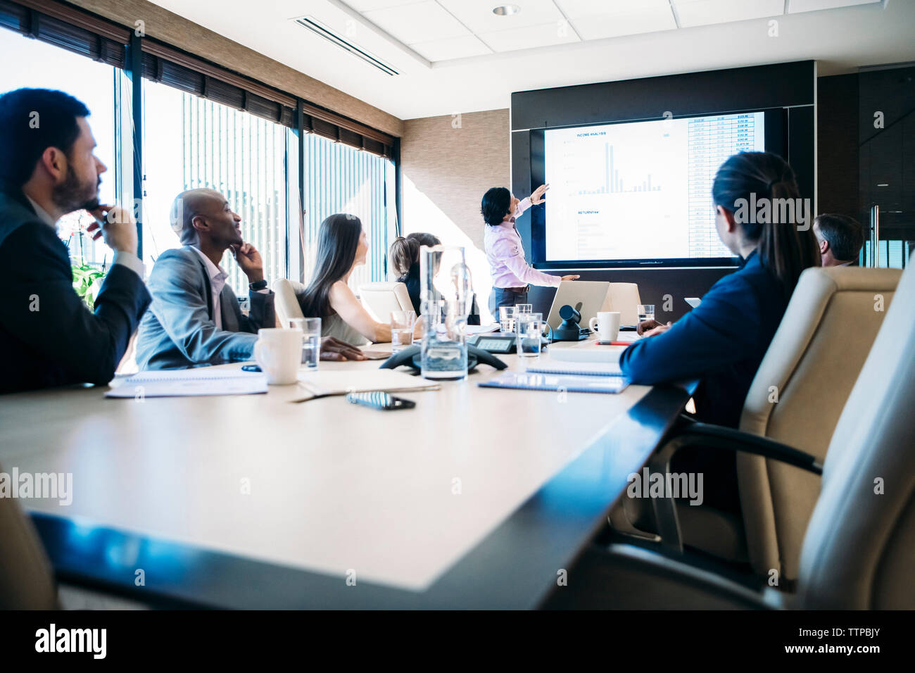 Kollegen suchen Bei Geschäftsmann, die Präsentation in der Sitzung Stockfoto