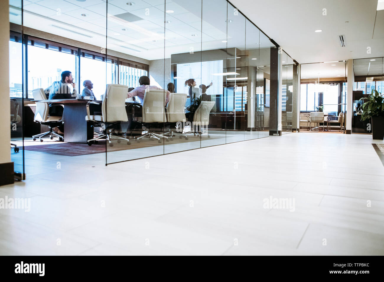 Geschäftsfrau hält Präsentation im Konferenzraum mit Blick durch ein Glasfenster Stockfoto