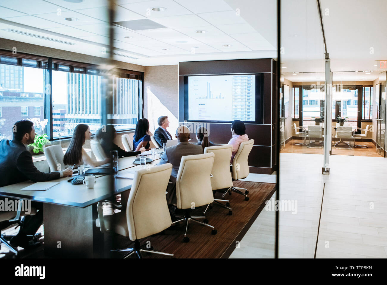 Geschäftsleute diskutieren in einem Konferenzraum, der durch die Tür gesehen wird Stockfoto