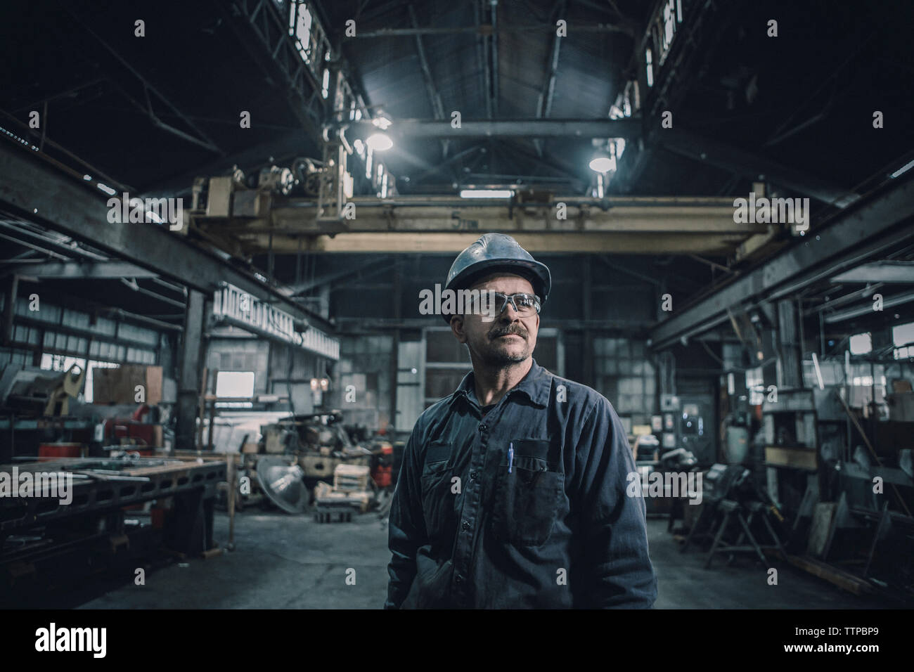 Männliche Arbeiter weg schauen beim Stehen in der Metallindustrie Stockfoto