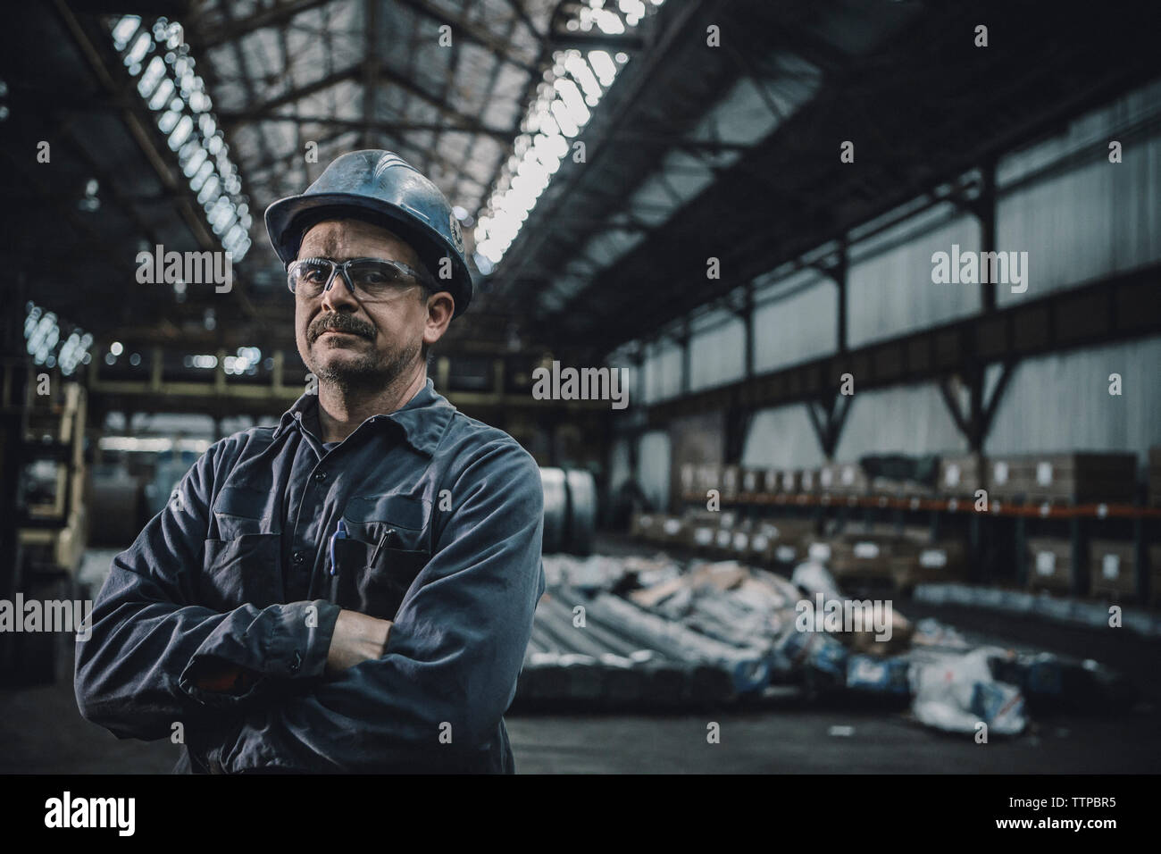 Portrait von zuversichtlich männlichen Arbeitnehmer mit gekreuzten Armen stehen in der Stahlindustrie Stockfoto