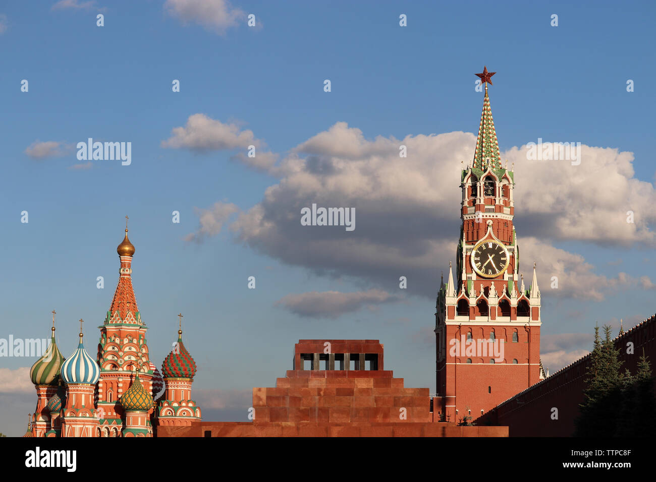 Blick auf den Kreml, die Basilius-Kathedrale und Lenin Mausoleum auf dem Roten Platz in Moskau. Spasskaja Turm gegen den blauen Himmel mit Wolken Stockfoto