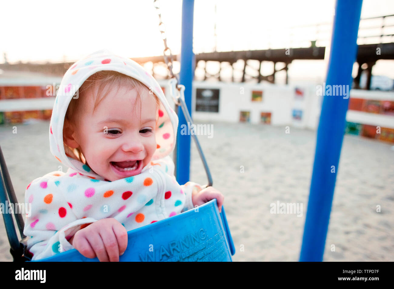 Happy Baby Mädchen schwingen auf Spielplatz Stockfoto