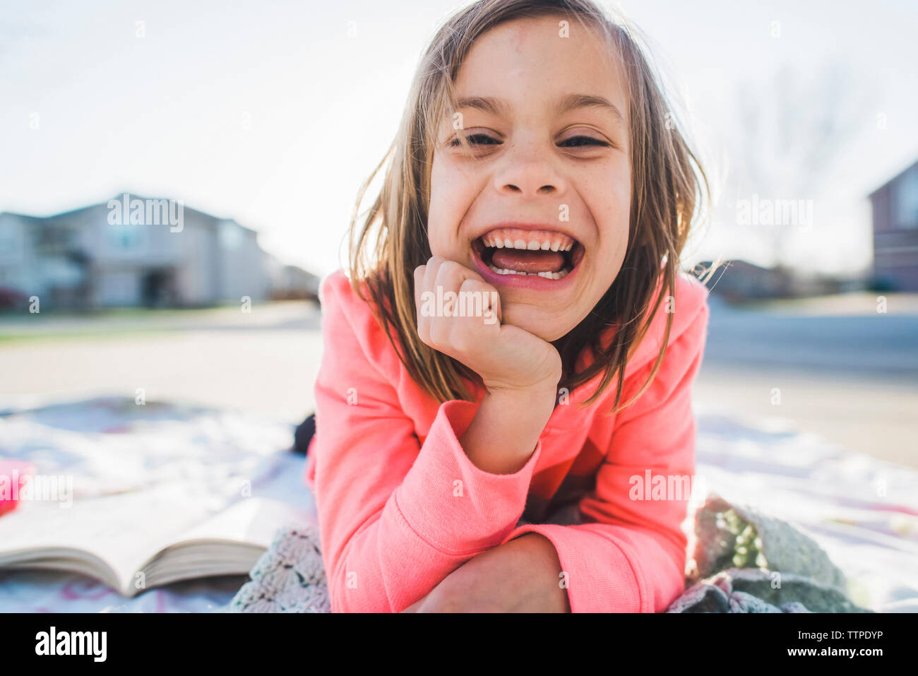 Portrait von fröhliches Mädchen mit der Hand am Kinn im Hof Stockfoto