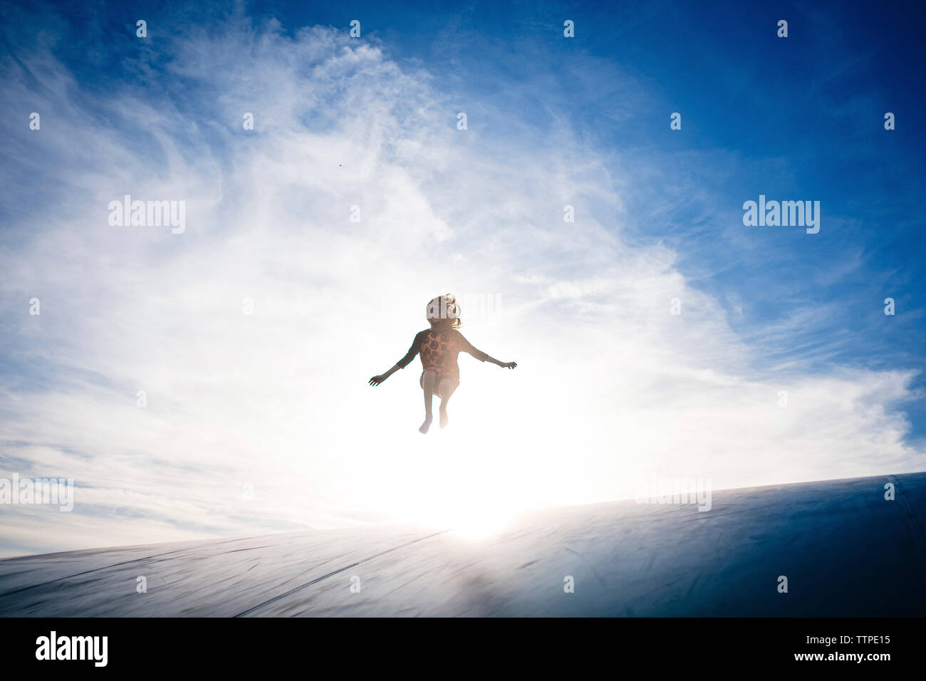 Happy girl Jumping auf Sport Rampe gegen Himmel während der sonnigen Tag Stockfoto