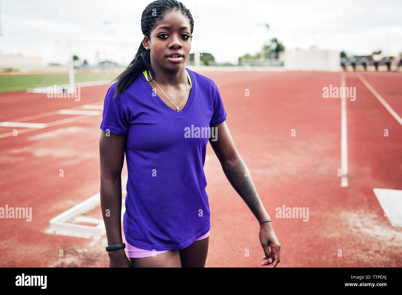 Portrait von zuversichtlich Sportlerin zu Fuß auf Running tracks Stockfoto