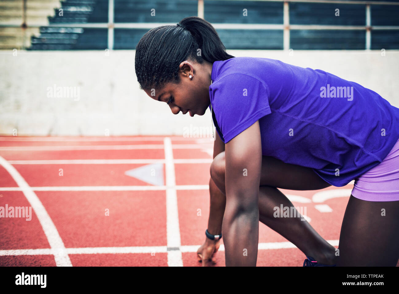 Seitenansicht der Sportlerin im Startblock auf Running tracks Stockfoto