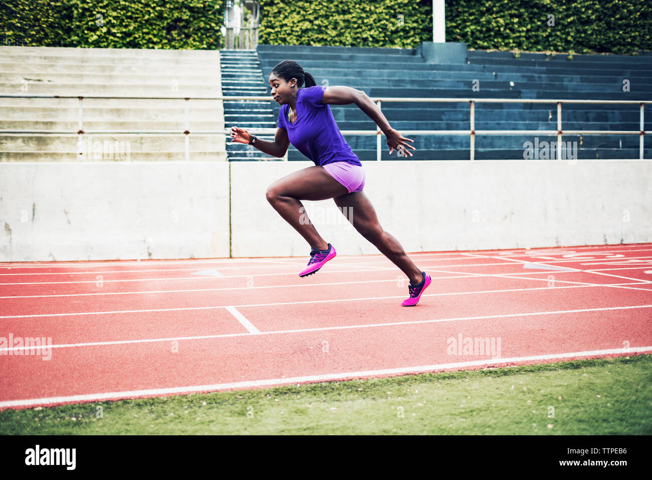 Die volle Länge der ermittelten weiblichen Athleten laufen auf Schienen Stockfoto