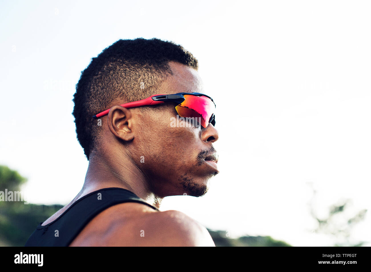 Low Angle View von nachdenklich männlichen Athleten tragen Sonnenbrillen gegen den klaren Himmel Stockfoto