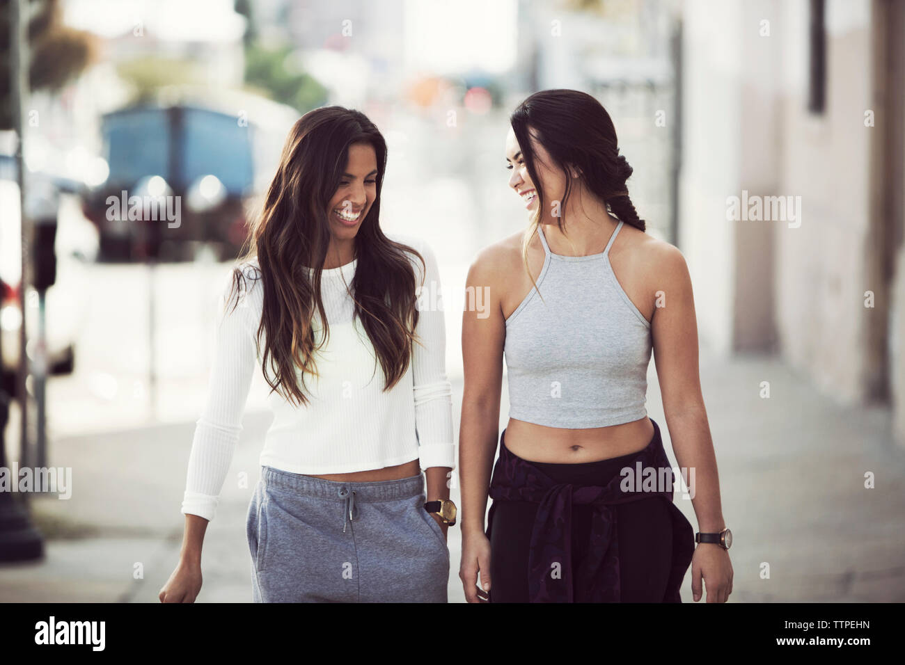 Gerne Freunde tragen sportliche Kleidung zu Fuß auf dem Bürgersteig in der Stadt Stockfoto