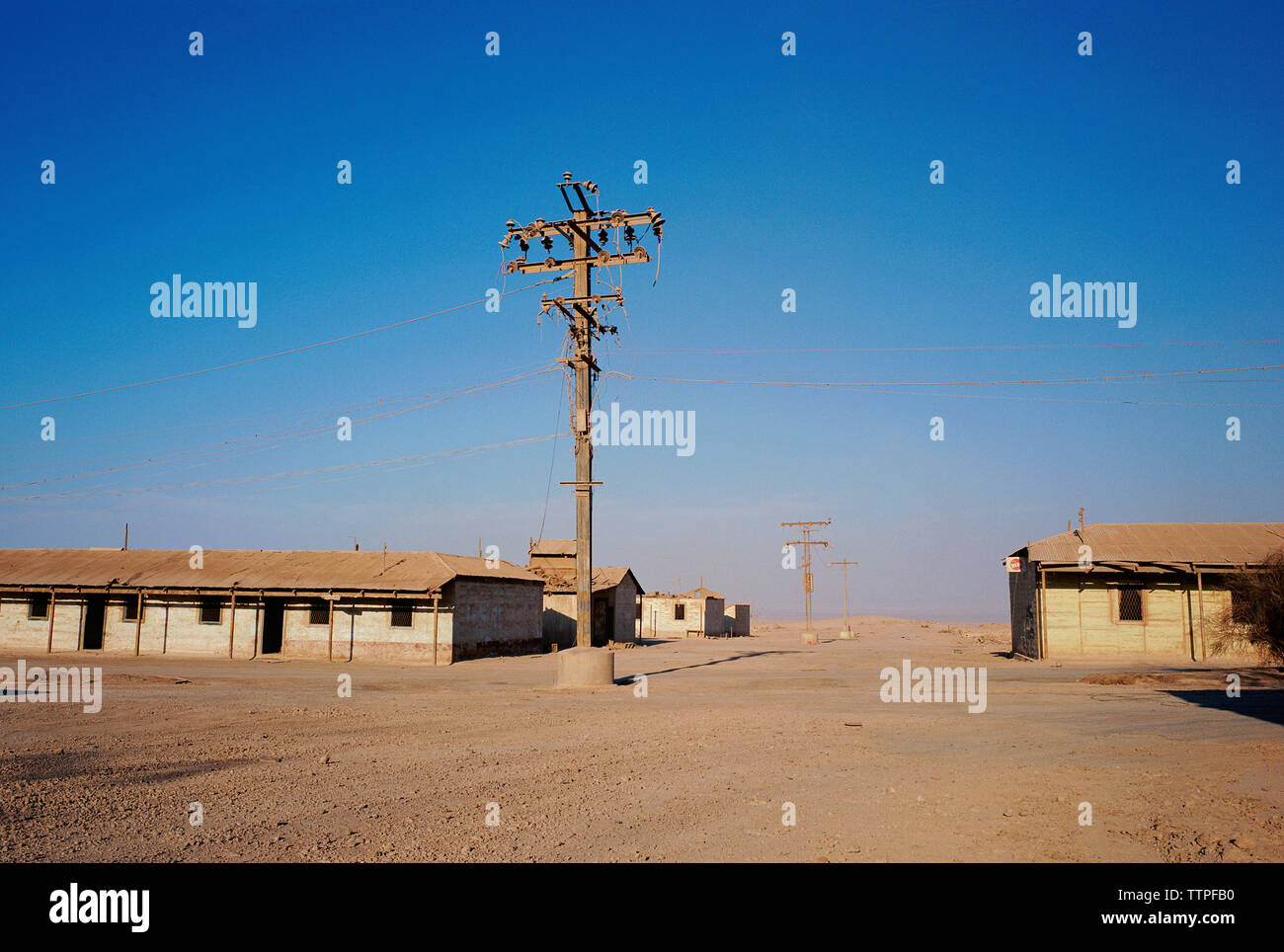Strom pylon auf Feld gegen blauen Himmel Stockfoto