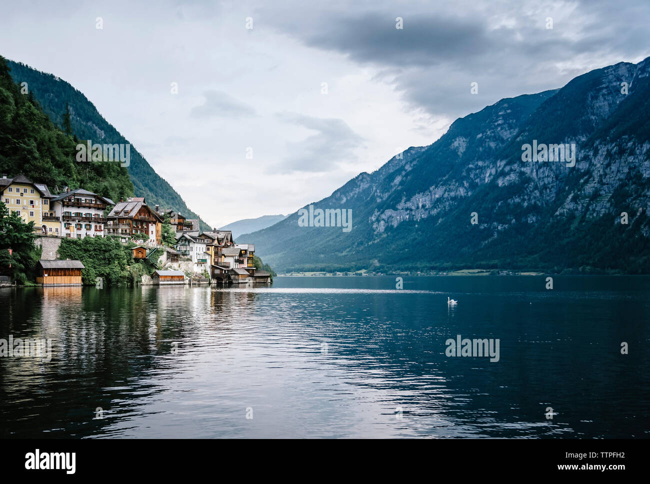 Häuser in der Stadt am See gegen Berge Stockfoto