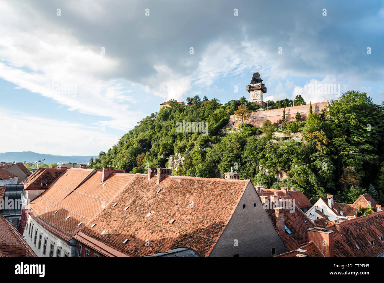 Häuser in der Stadt gegen Schlossberg und bewölkter Himmel Stockfoto