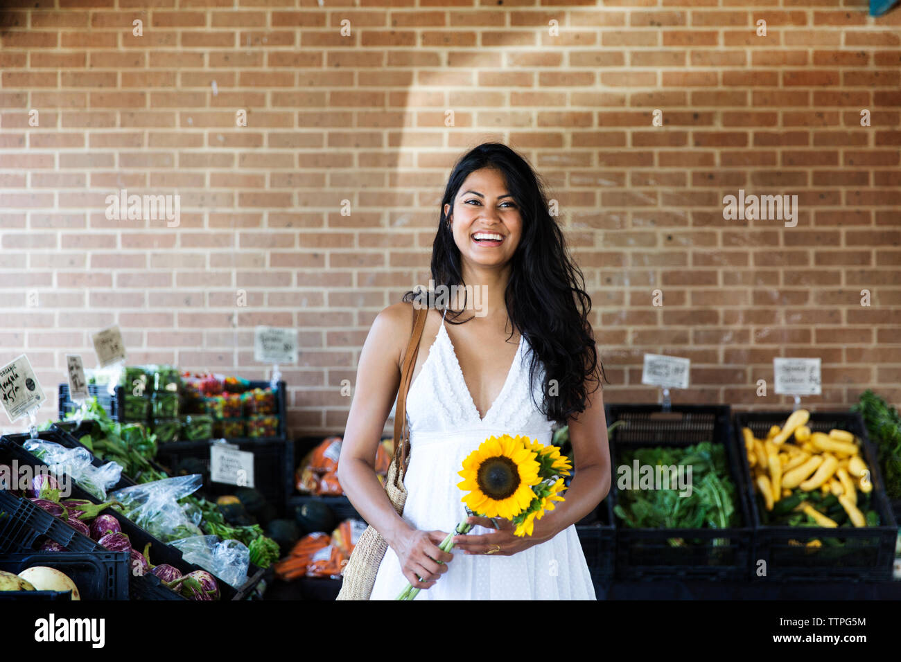 Gerne Frau mit Sonnenblumen und Marktposition Stockfoto
