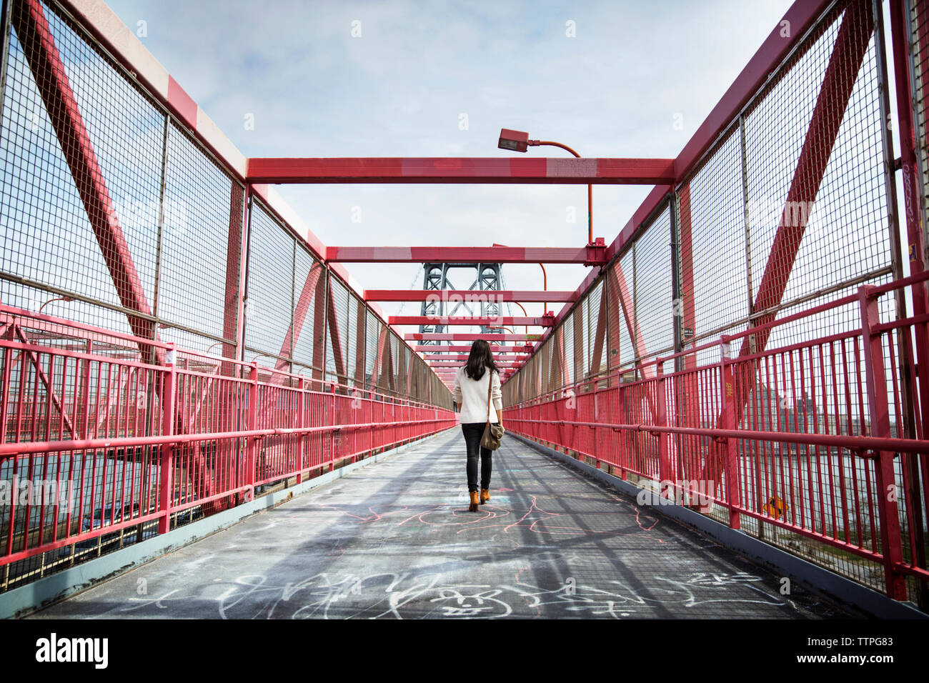 Ansicht der Rückseite des jungen Frau, die über die Williamsburg Bridge Stockfoto