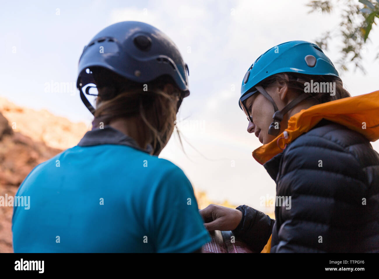 Wanderer mit Helm beim Lesen Ratgeber Stockfoto