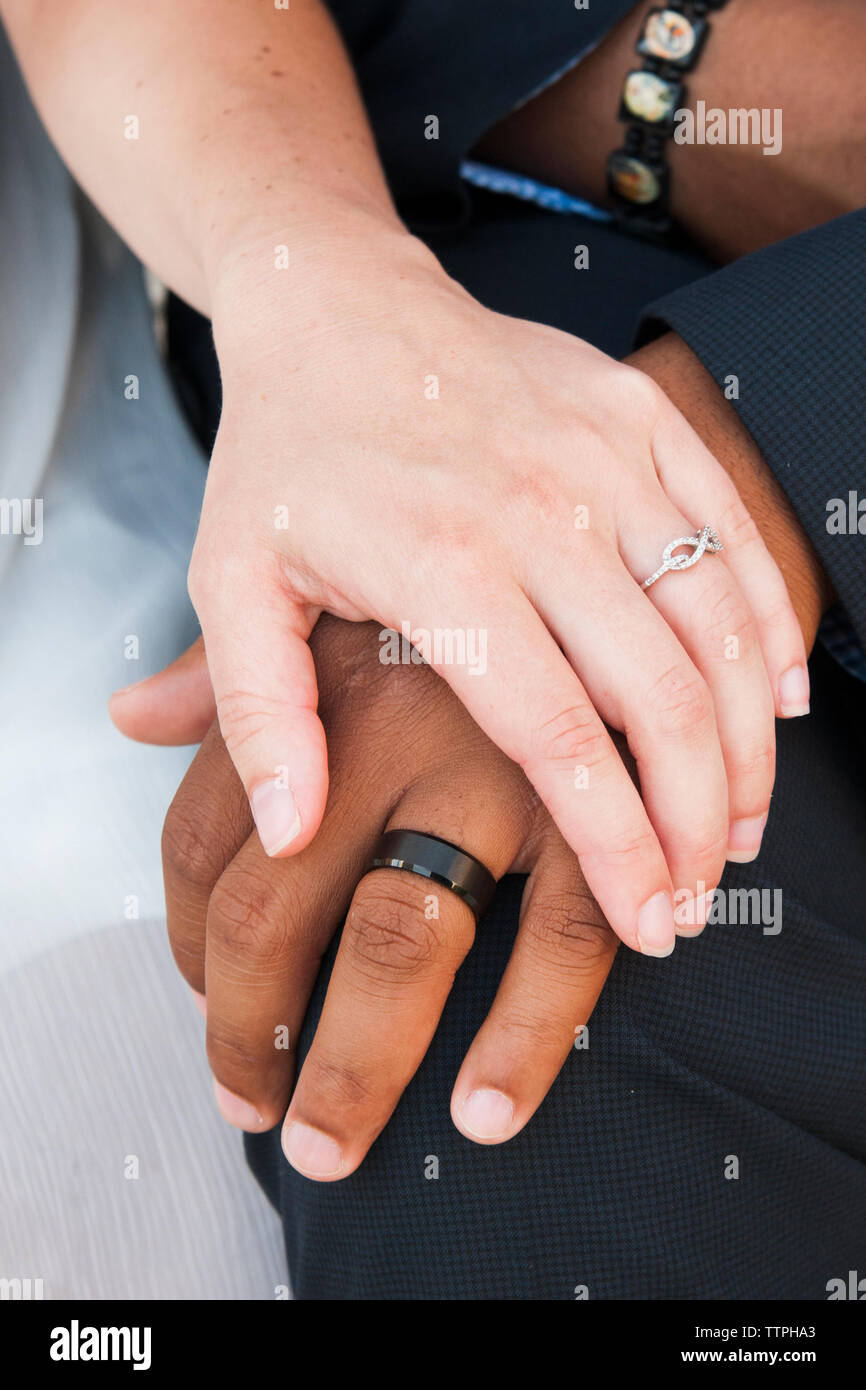 Interracial Paar Hände mit Trauringe Stockfoto