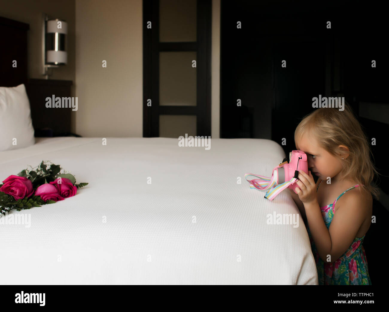 Seitliche Sicht auf Mädchen Fotografieren von Rosen auf das Bett zu Hause. Stockfoto