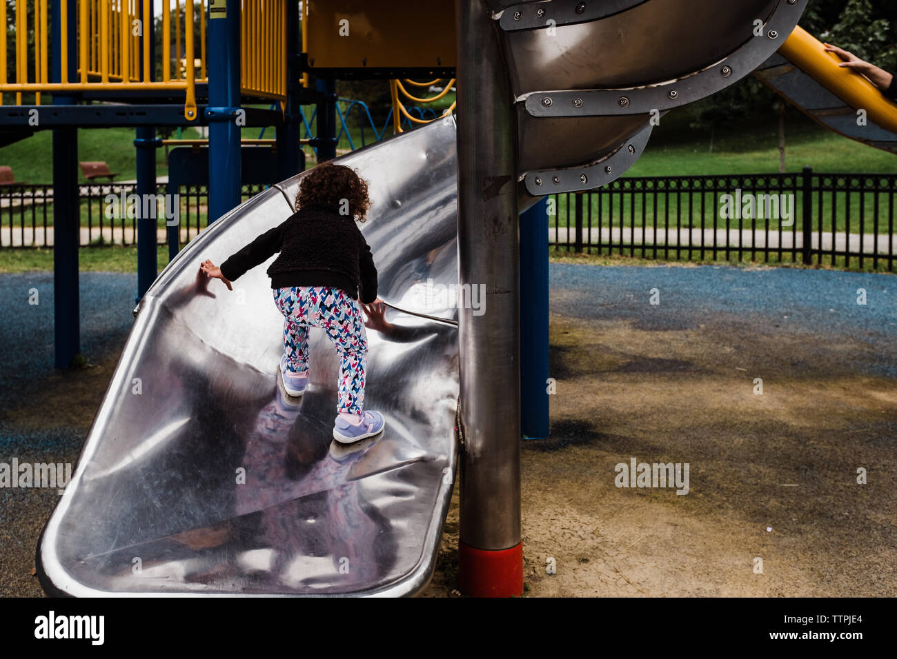 Kleines Mädchen klettern Rutsche auf dem Spielplatz Stockfoto