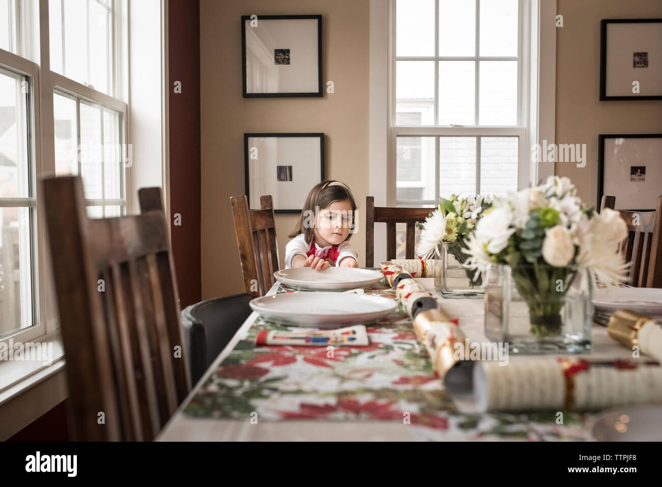 Mädchen, die den Teller auf dem Esstisch zu Hause während weihnachten einstellen Stockfoto
