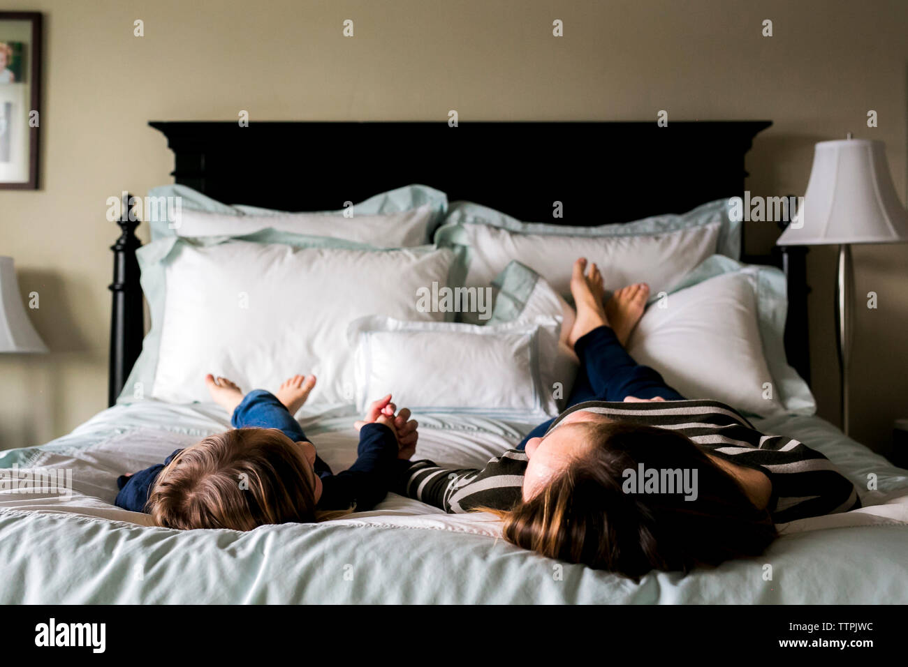 Mutter und Tochter auf dem Bett zu Hause liegen Stockfoto