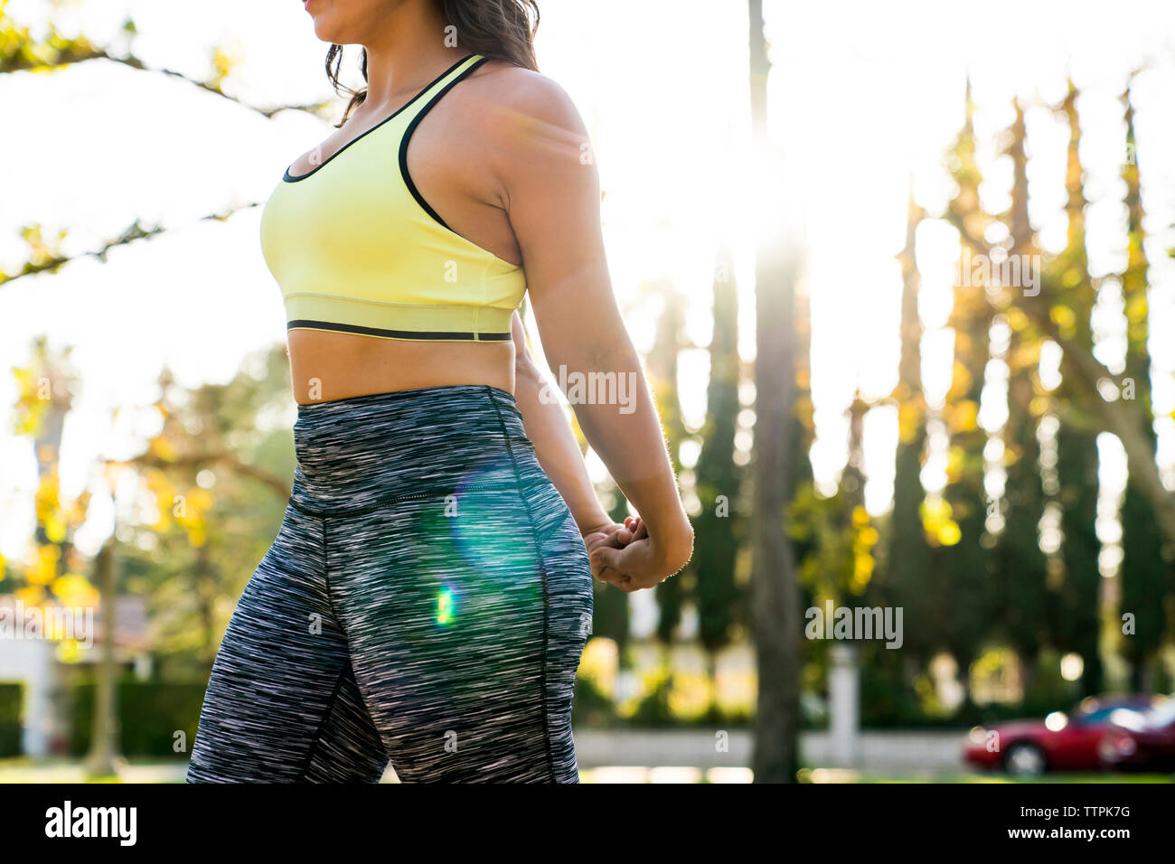 Mittelteil der Frau stretching Arme hinter dem Rücken, während die Ausübung in Park Stockfoto