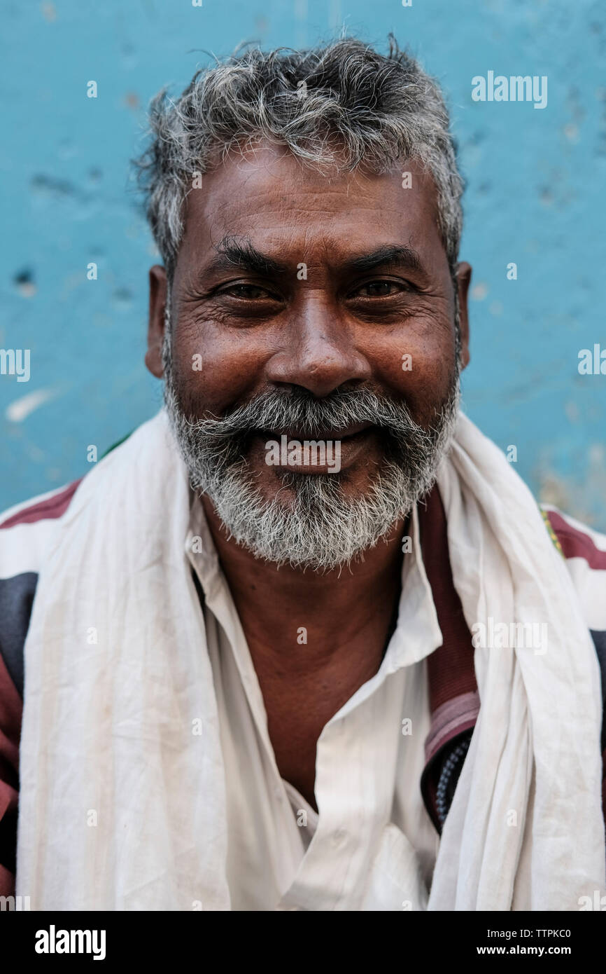 Portrait von lächelnden Bärtigen reifer Mann mit weißem Schal gegen die Wand in der Stadt Stockfoto