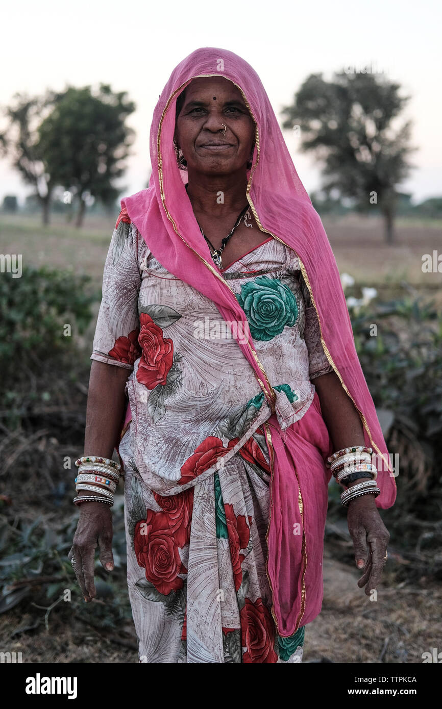 Portrait von lächelnden Mitte der erwachsenen Frau in traditioneller Kleidung stehend auf dem Feld Stockfoto