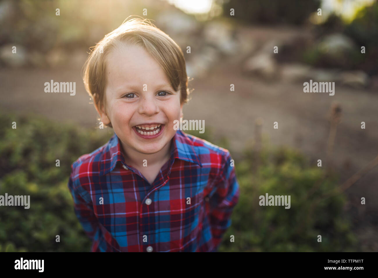 Portrait von fröhlicher Junge im Park Stockfoto