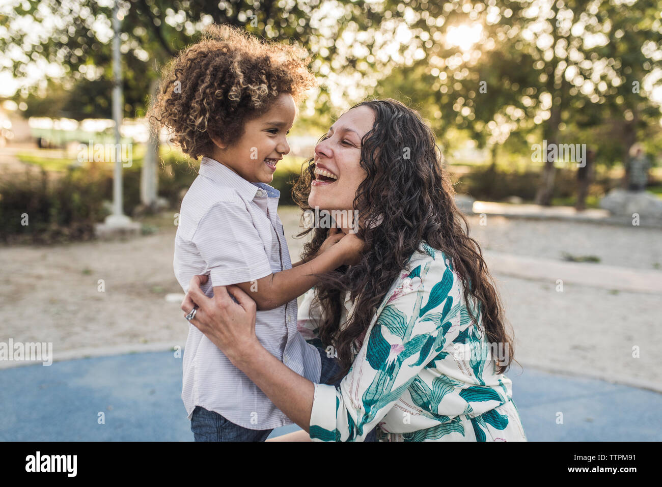 Fröhliche Mutter und Sohn spielen im Park Stockfoto