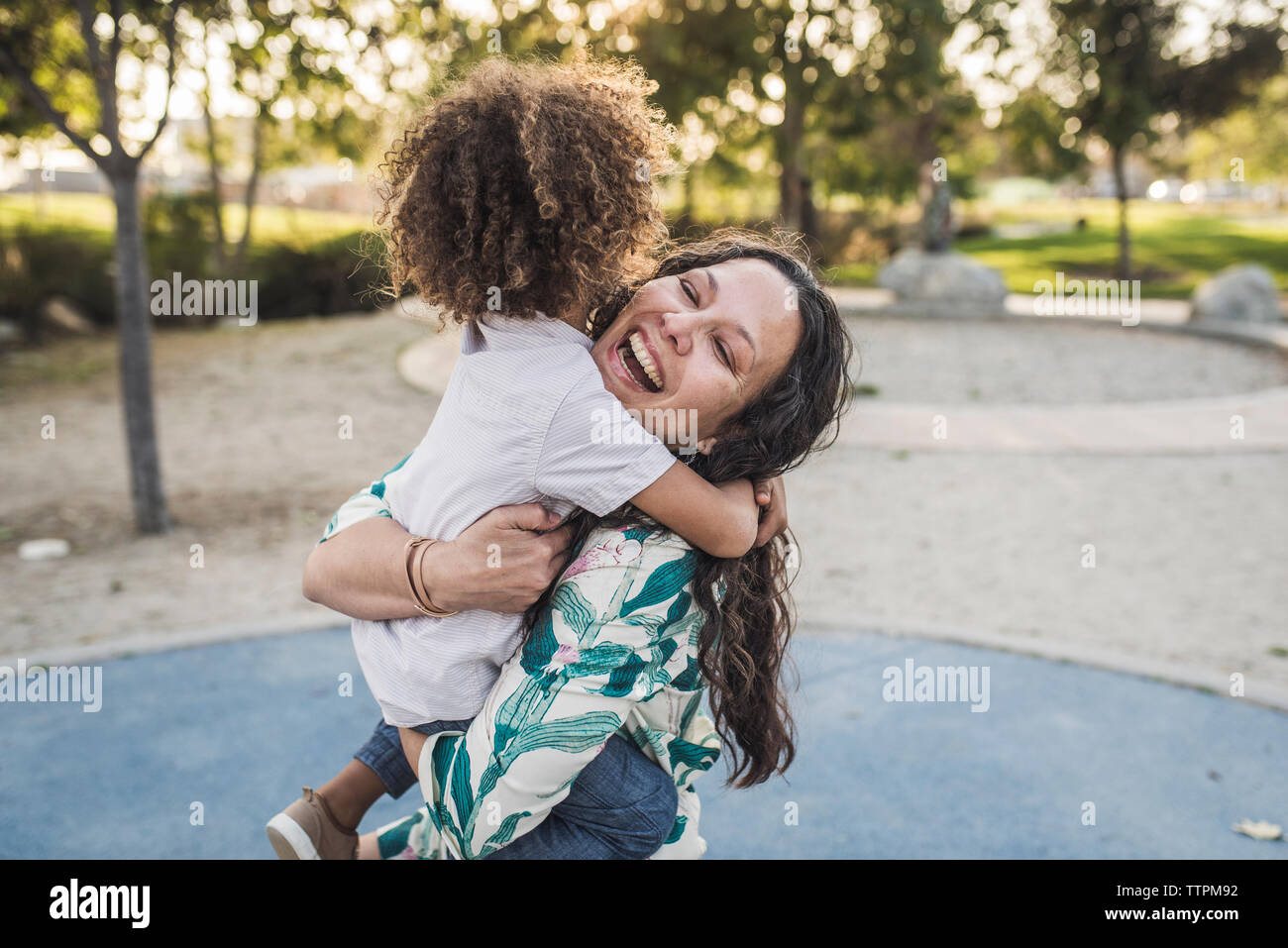 Fröhliche Mutter umarmt der Sohn im Park Stockfoto