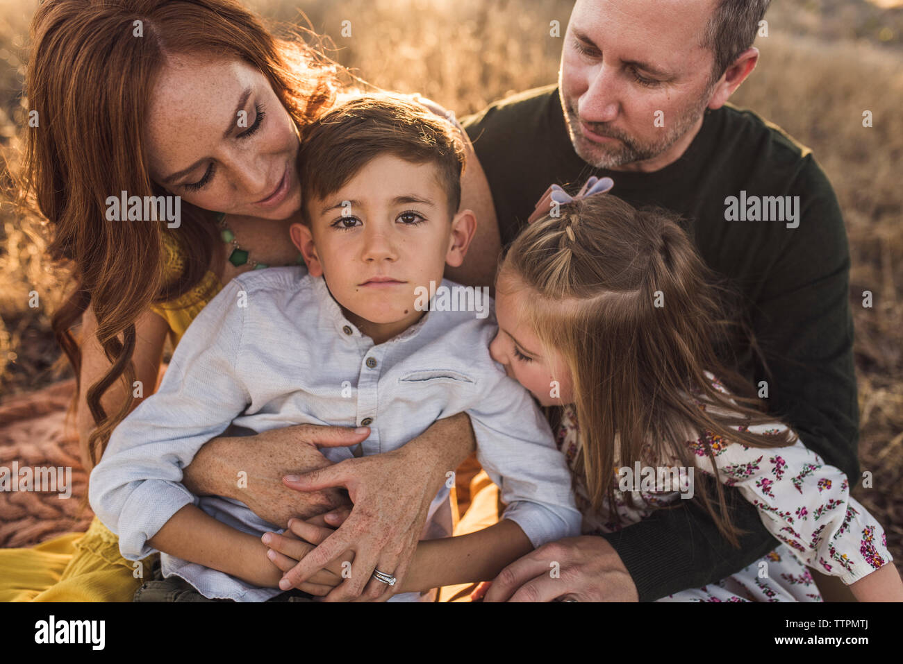 Nahaufnahme von Jungen durch Familie umarmt mit Kamera Stockfoto