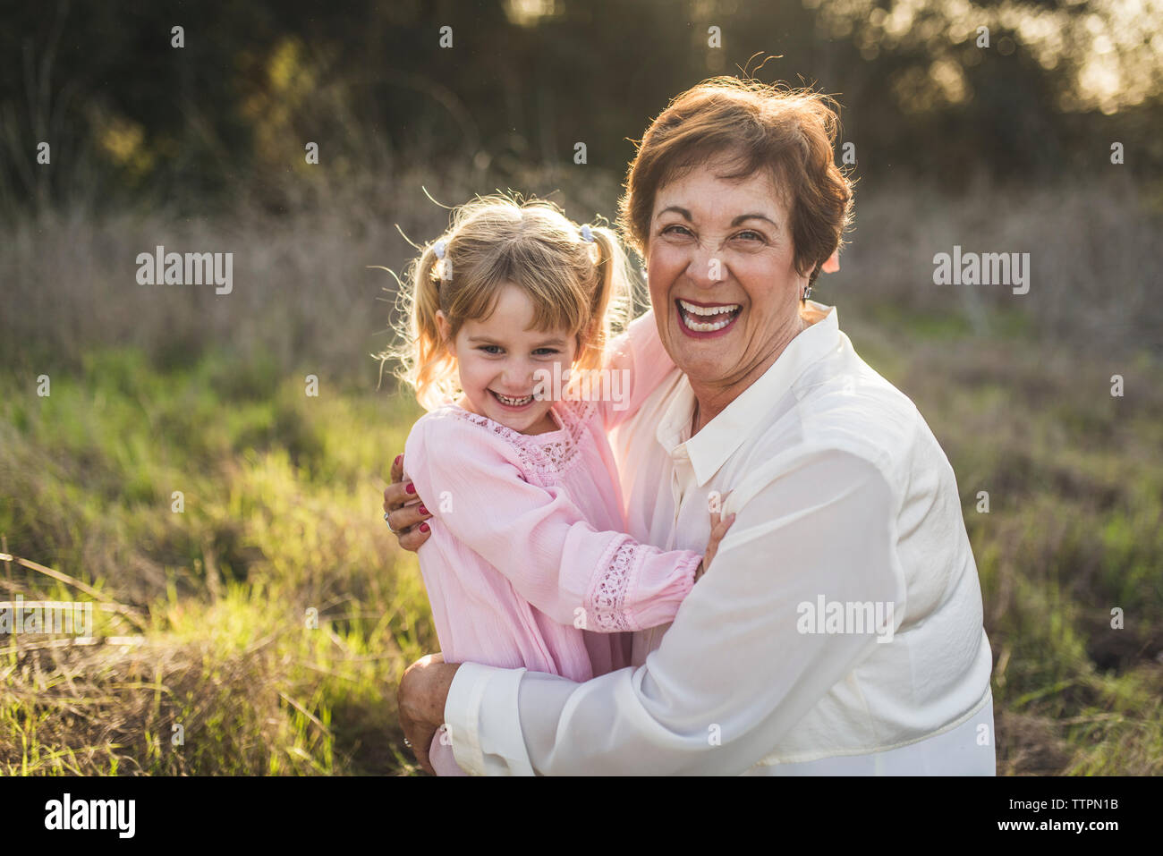 Portrait von Großmutter und Enkelin umarmen und Lachen Stockfoto