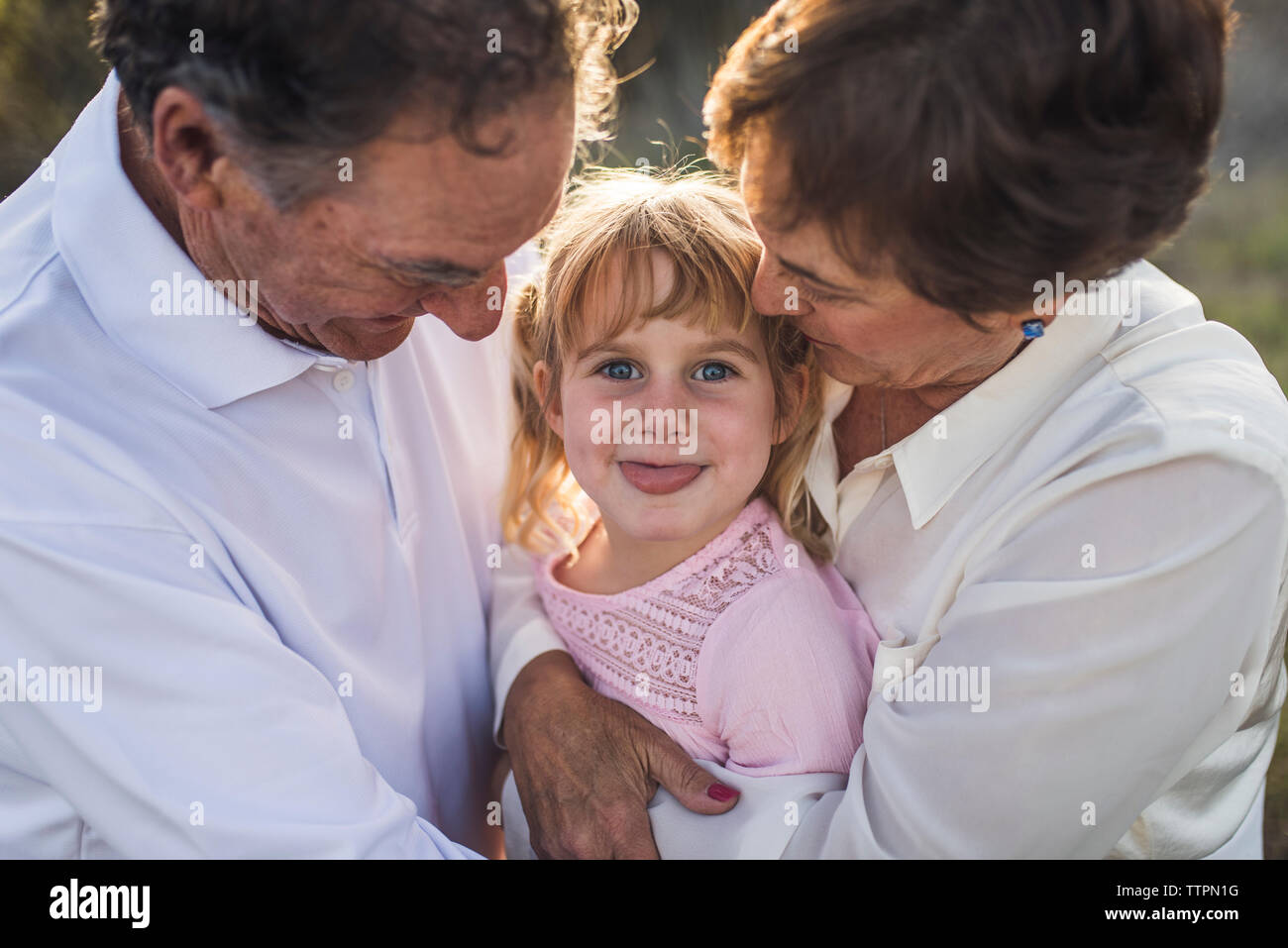 Close up Portrait von Großeltern umarmen Enkelin, lustige Gesichter Stockfoto