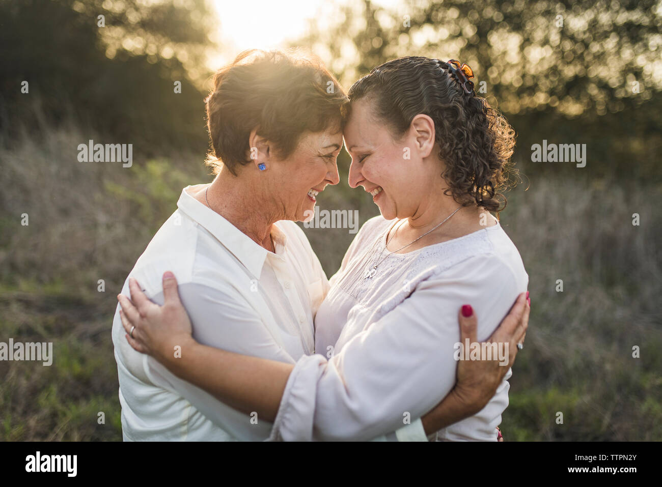 Close up Portrait von Erwachsenen Mutter und Tochter umarmen und lächelnd Stockfoto