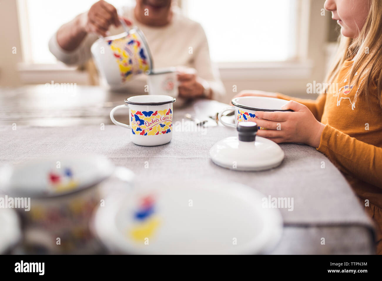 Nahaufnahme des jungen Mädchens und Urgroßmutter spielen mit Tee Set Stockfoto