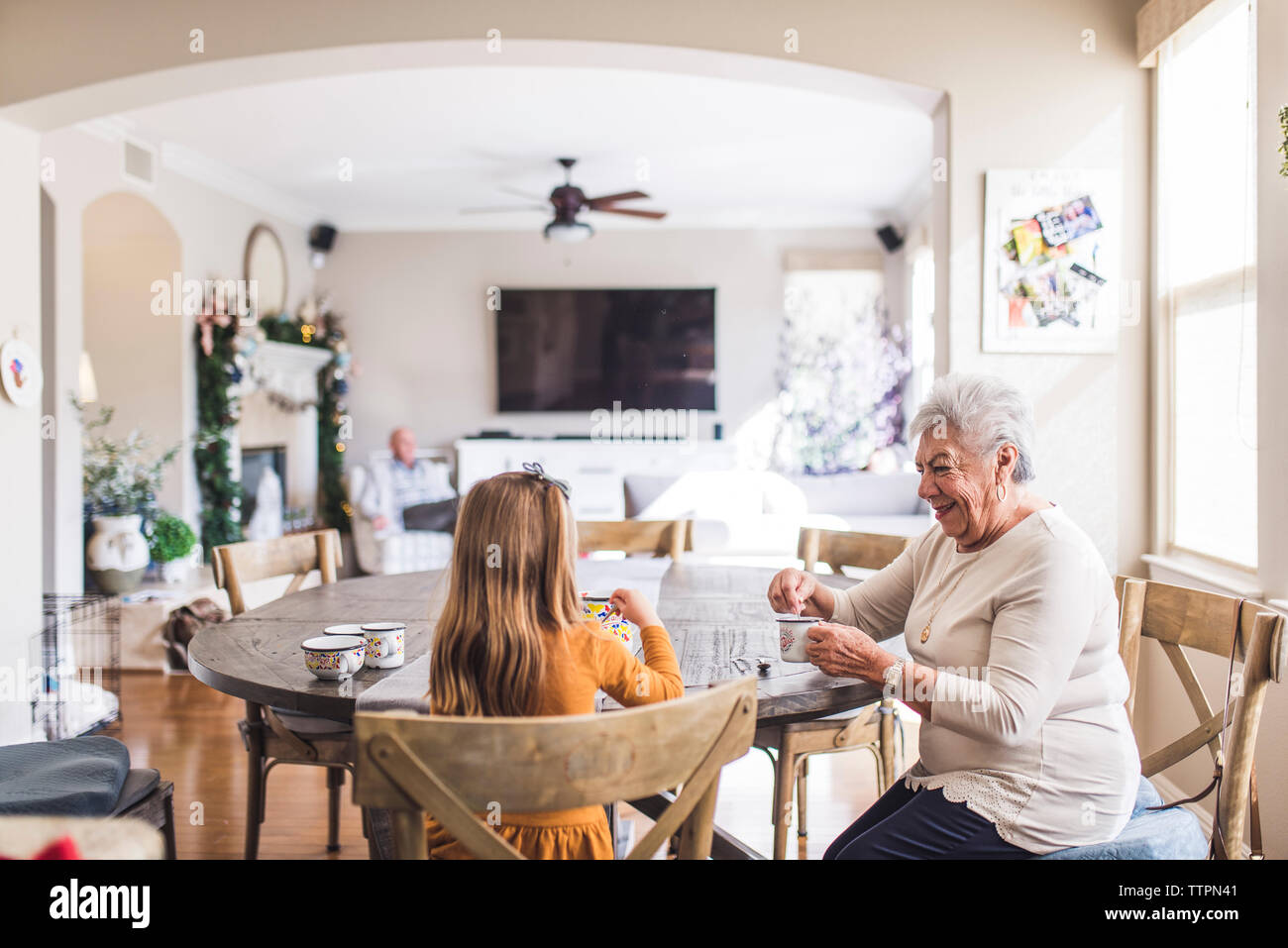 Mehr-generationen-Familie spielen mit Kaffee am Küchentisch gesetzt Stockfoto