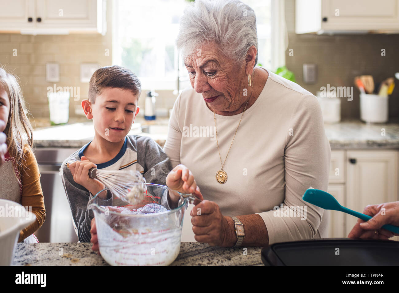 Enkel und Oma Frühstück machen Pfannkuchen in der Küche Stockfoto