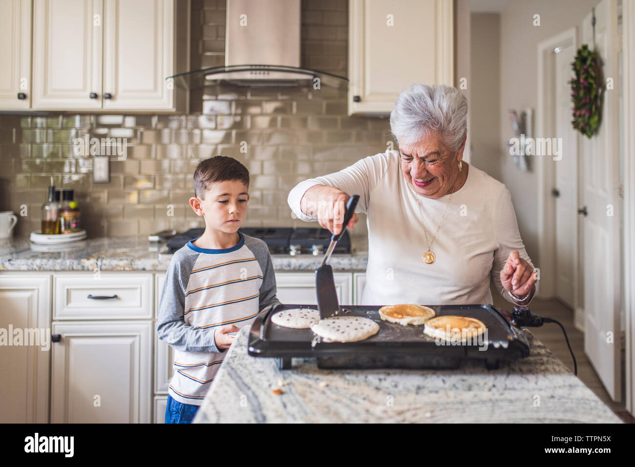 Super Oma und Enkel Pfannkuchen in der Küche Stockfoto