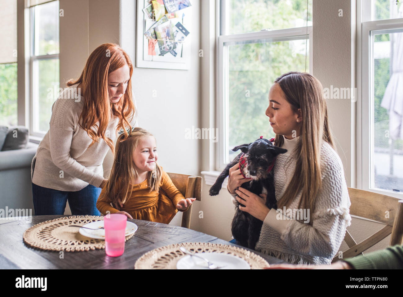 Mehr-generationen-Familie und kleiner Hund essen Pfannkuchen zum Frühstück Stockfoto