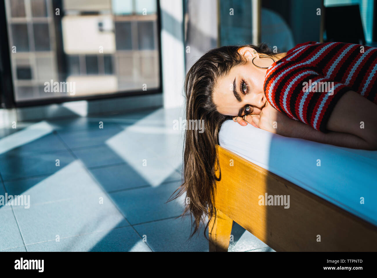 Porträt der jungen Frau auf Bett zu Hause Stockfoto